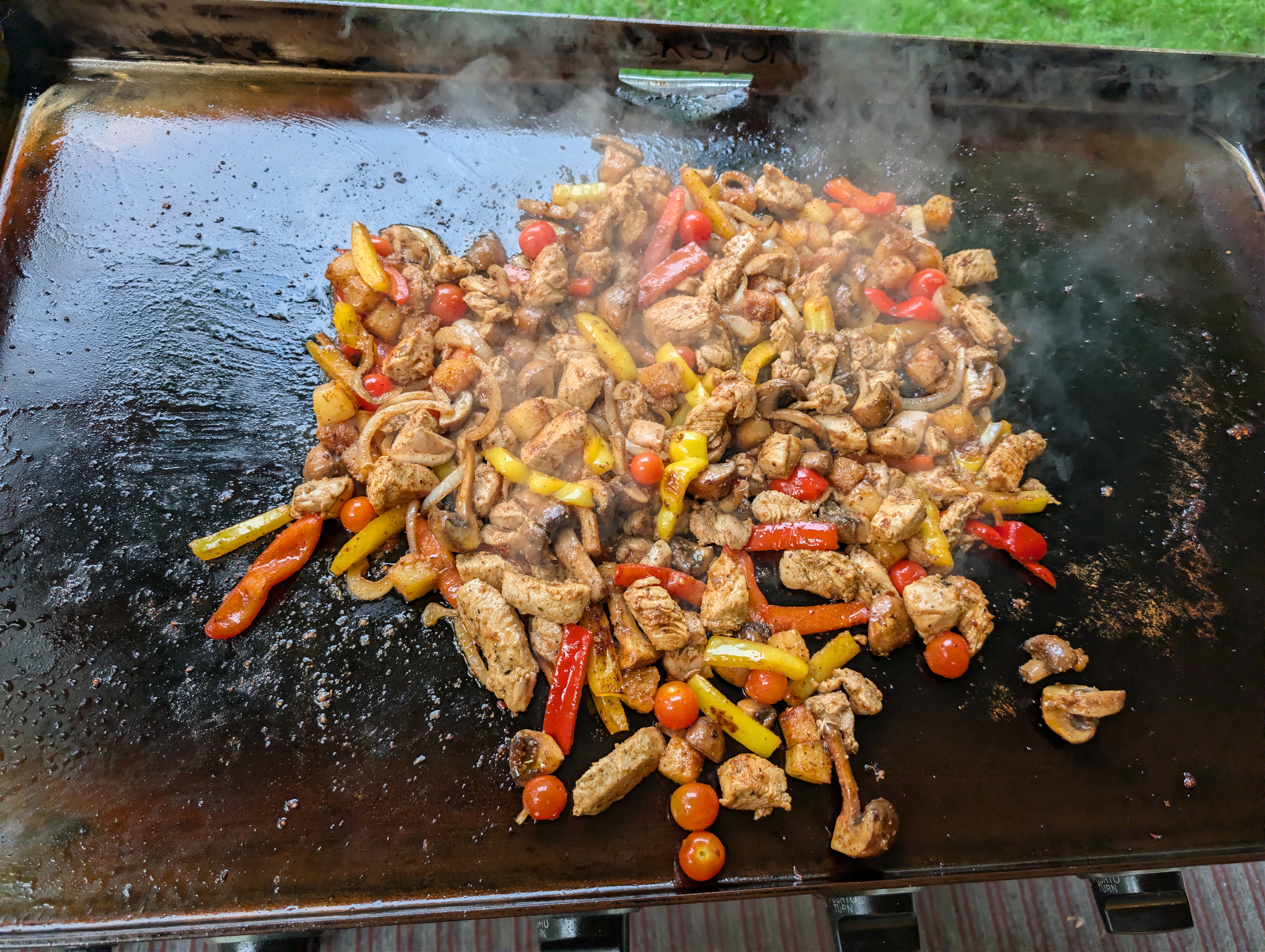 Papa's Chicken Sh#t on the Blackstone griddle, chicken, peppers, mushrooms, and cherry tomatoes, all mixed and steaming
