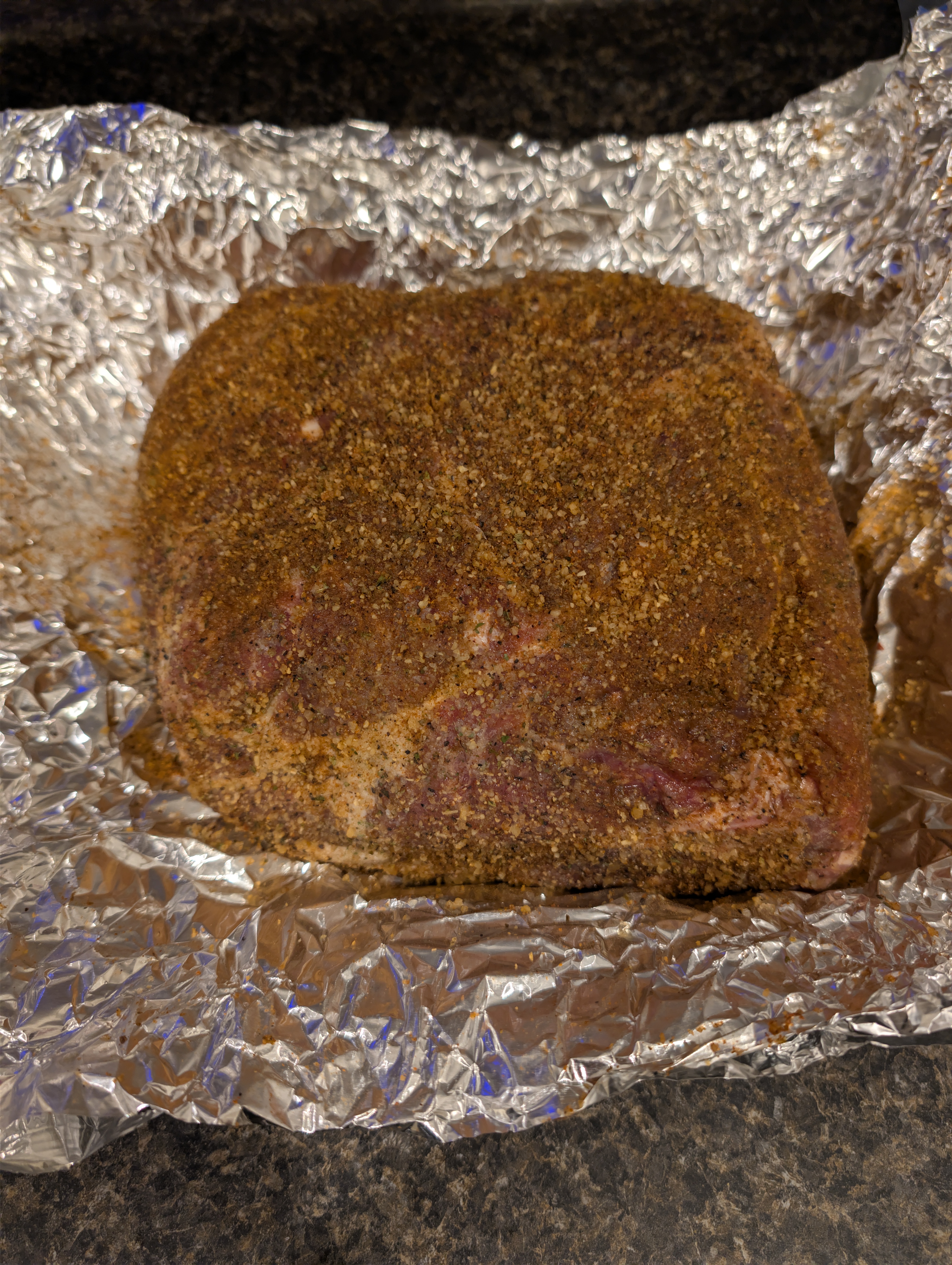 Raw pork shoulder seasoned for pulled pork