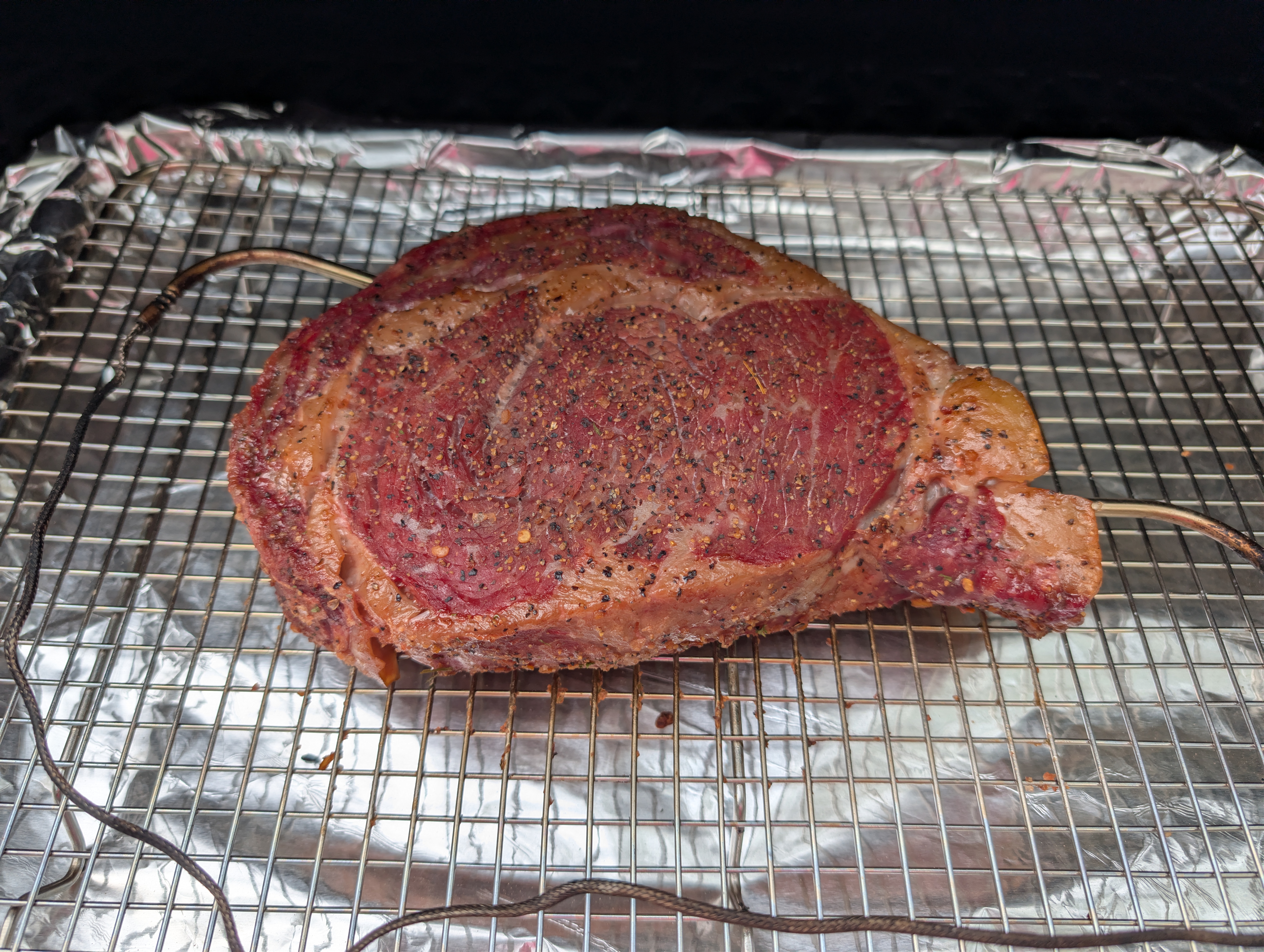 Seasoned ribeye on the Pit Boss pellet grill grates at 225°F
